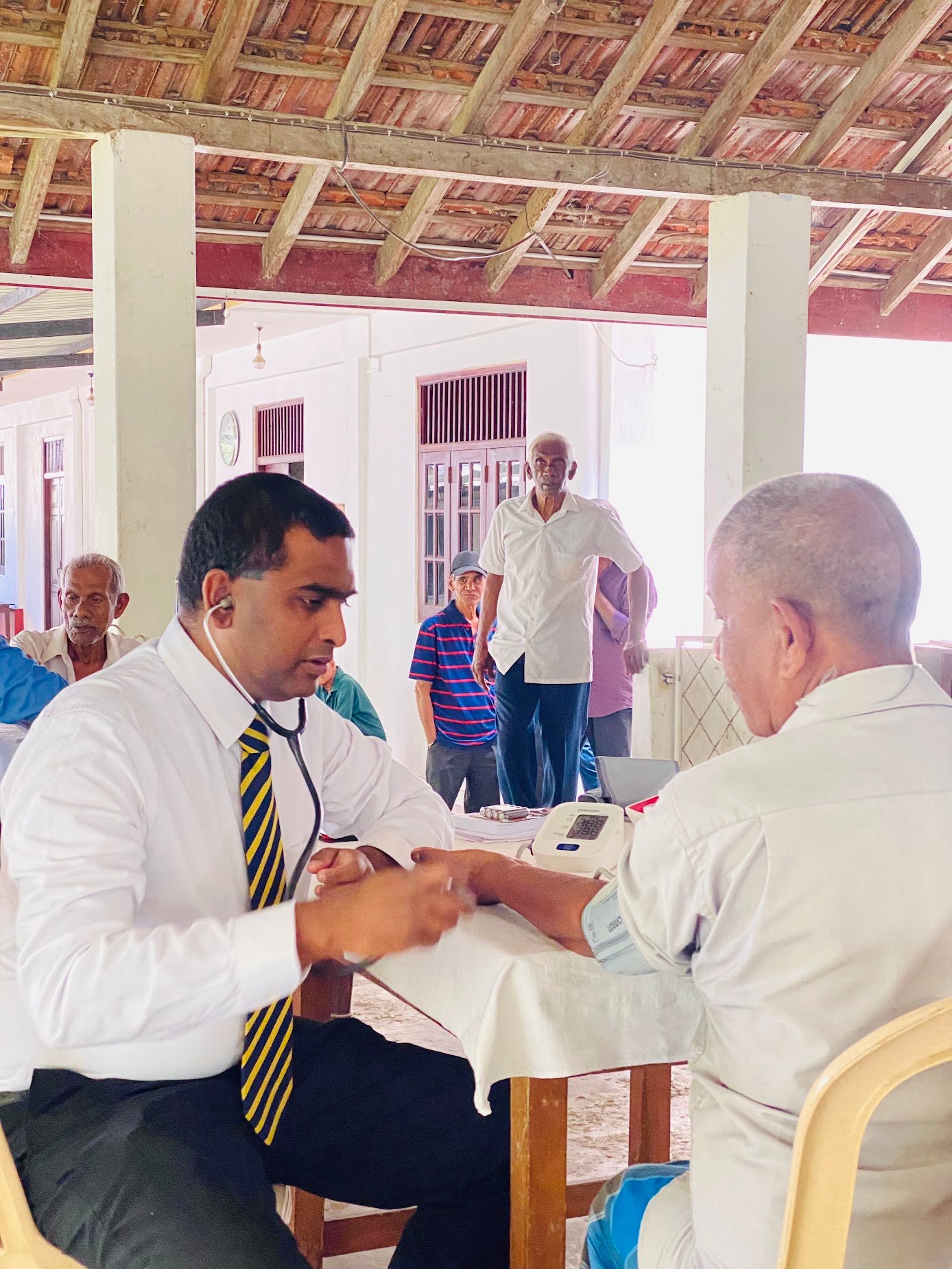 H4H volunteer conducting blood pressure screening